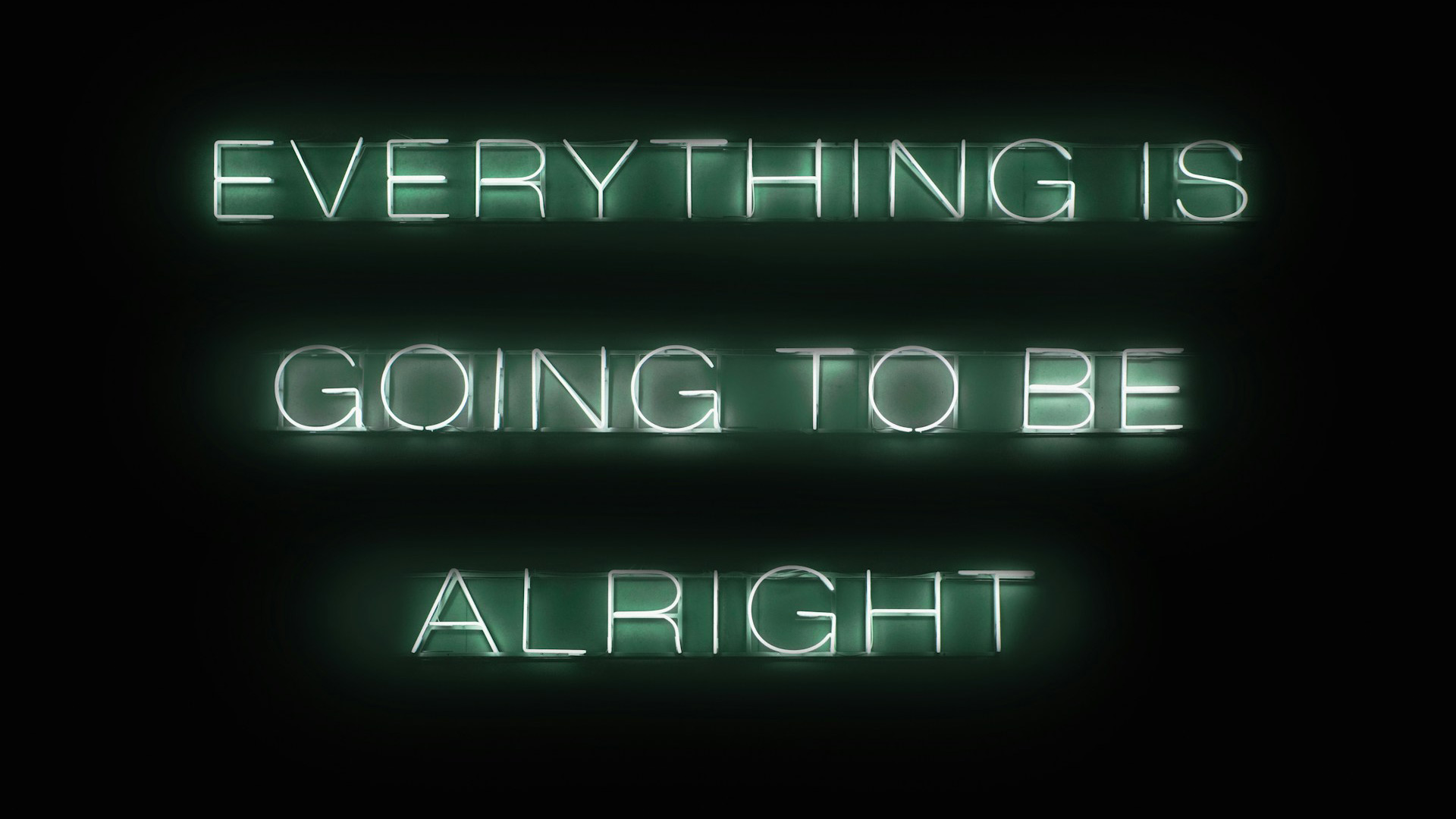 A bluish green neon sign says "Everything is going to be alright."