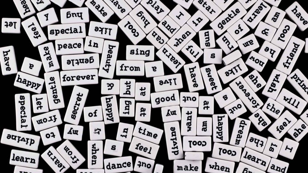 A pile of tiles, each one with a different word engraved on it.