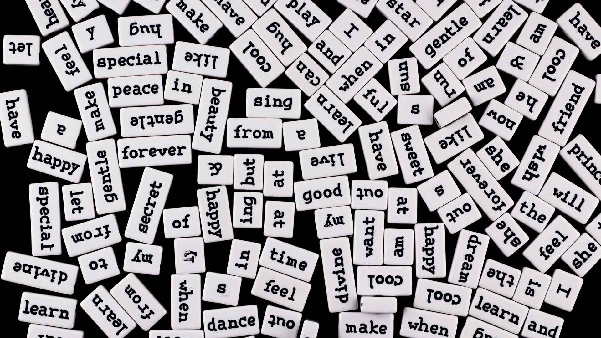 A pile of tiles, each one with a different word engraved on it.