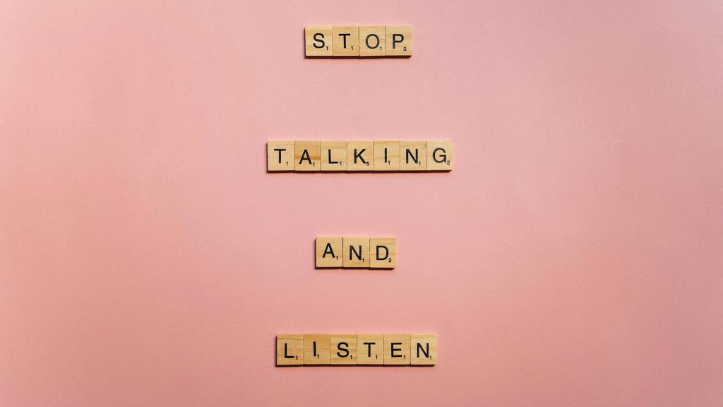Scrabble™ tiles spell out the sentence, "Stop talking and listen."