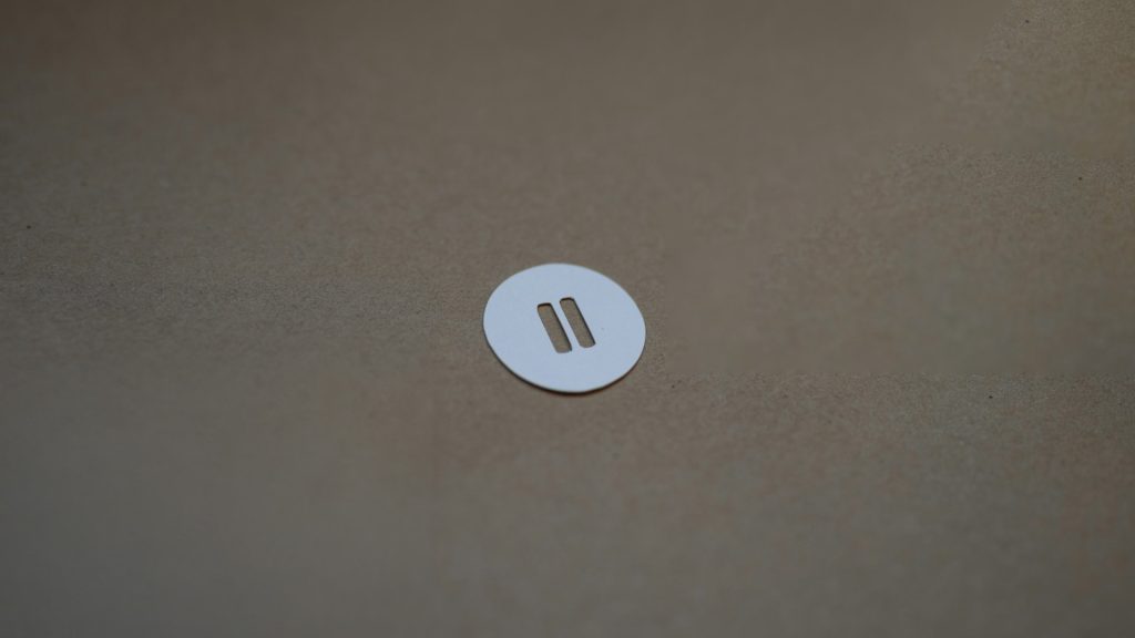 A piece of paper cut out to look like a pause button.